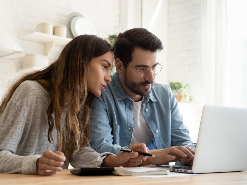 Mann und Frau schauen in ein Laptop