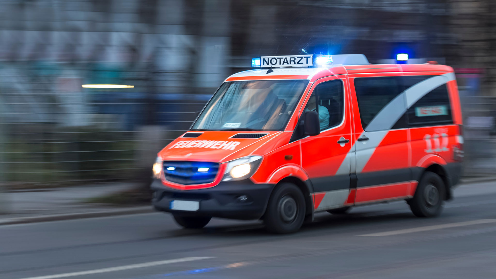 Ein Notarztfahrzeug der Feuerwehr bei einer Einsatzfahrt mit Blaulicht.