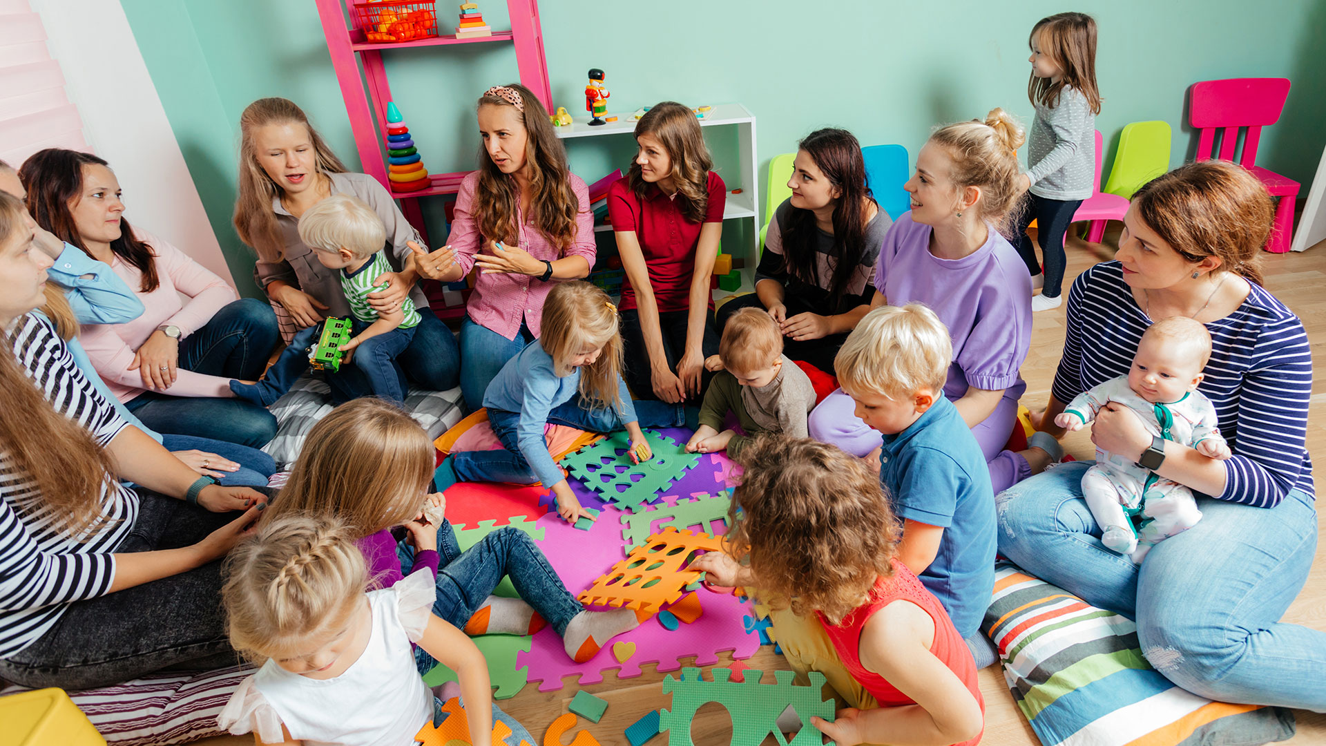 Mütter mit kleinen Kindern sprechen mit einer Erzieherin