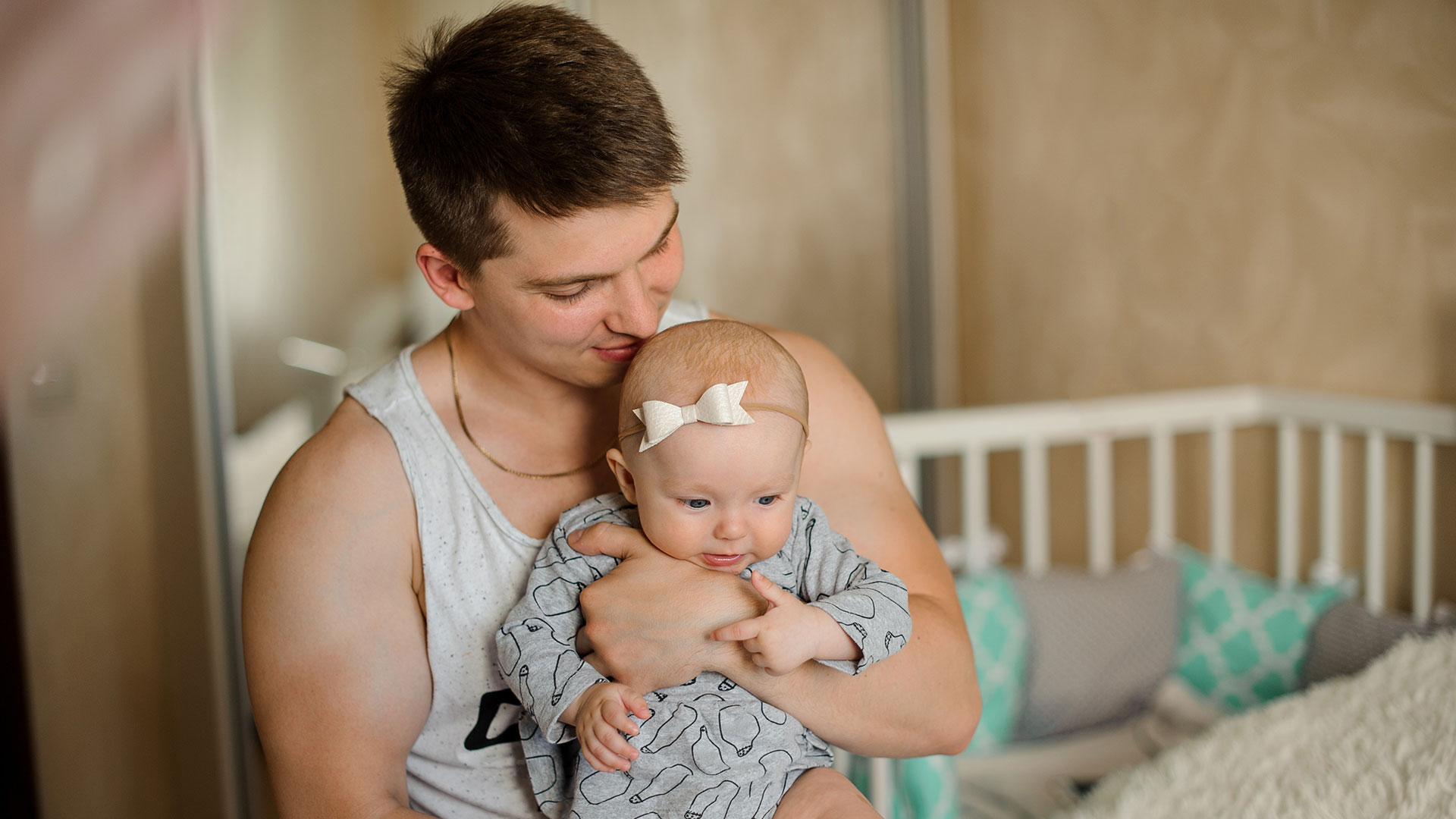 Junger Vater hält ein Baby auf dem Arm