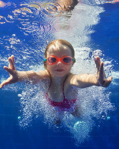 Schwimmendes Kind mit Taucherbrille unter Wasser 